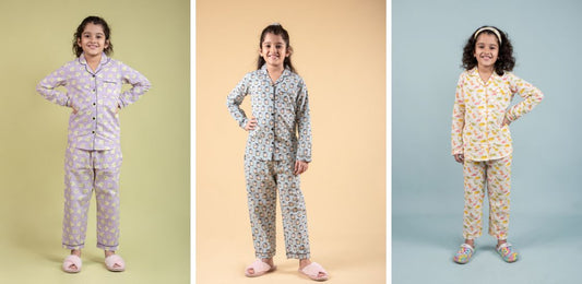 Young girls wearing colorful printed night suits for kids, posing on pastel backgrounds
