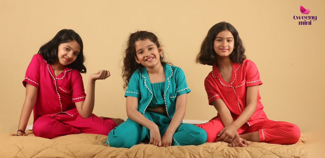 Three girls in colorful night suits sitting on a bed, kids sleepwear, comfortable pajamas