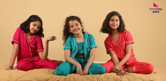 Three girls in colorful night suits sitting on a bed, kids sleepwear, comfortable pajamas