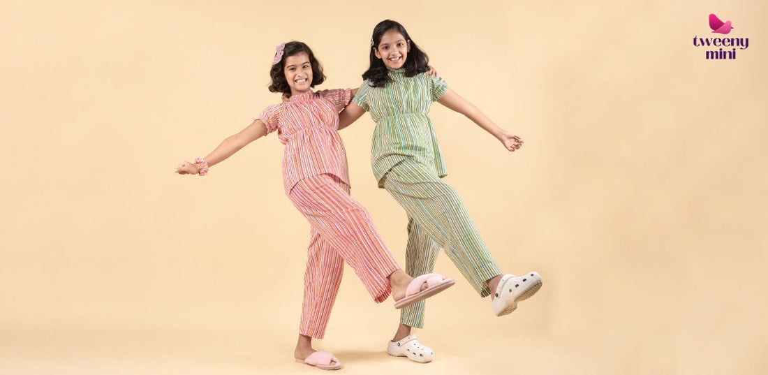 Two smiling girls in colorful striped nightwear sets posing playfully against a beige background