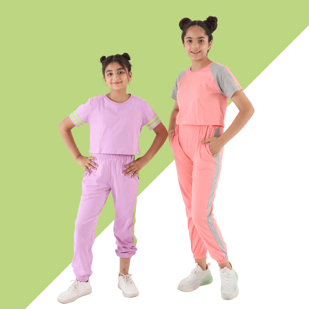 Two girls in pastel casual outfits, lilac and peach jogger sets, standing on color block background
