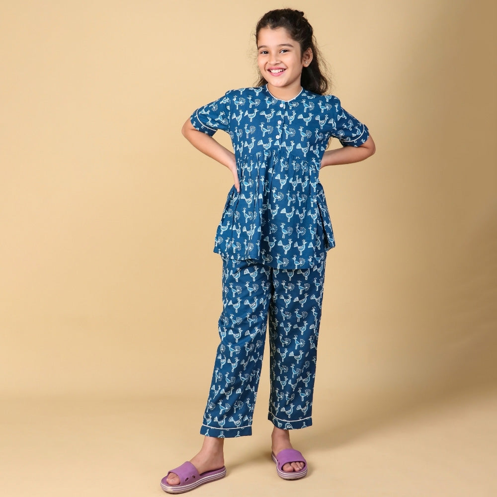 Smiling girl in blue printed night suit set for kids, stylish and comfortable sleepwear fashion.