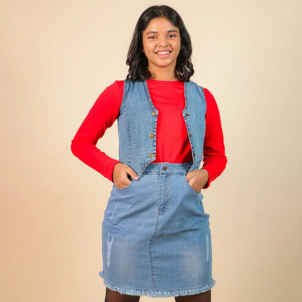 Girl wearing a denim waistcoat and skirt over a red long sleeve top, kids fashion outfit