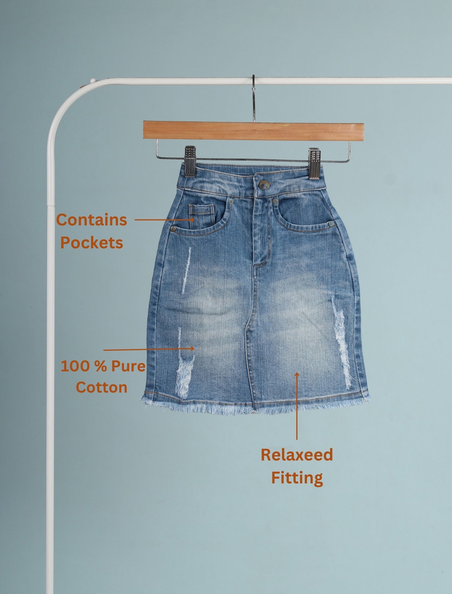 Blue denim skirt on a hanger with text highlighting features against a light blue background