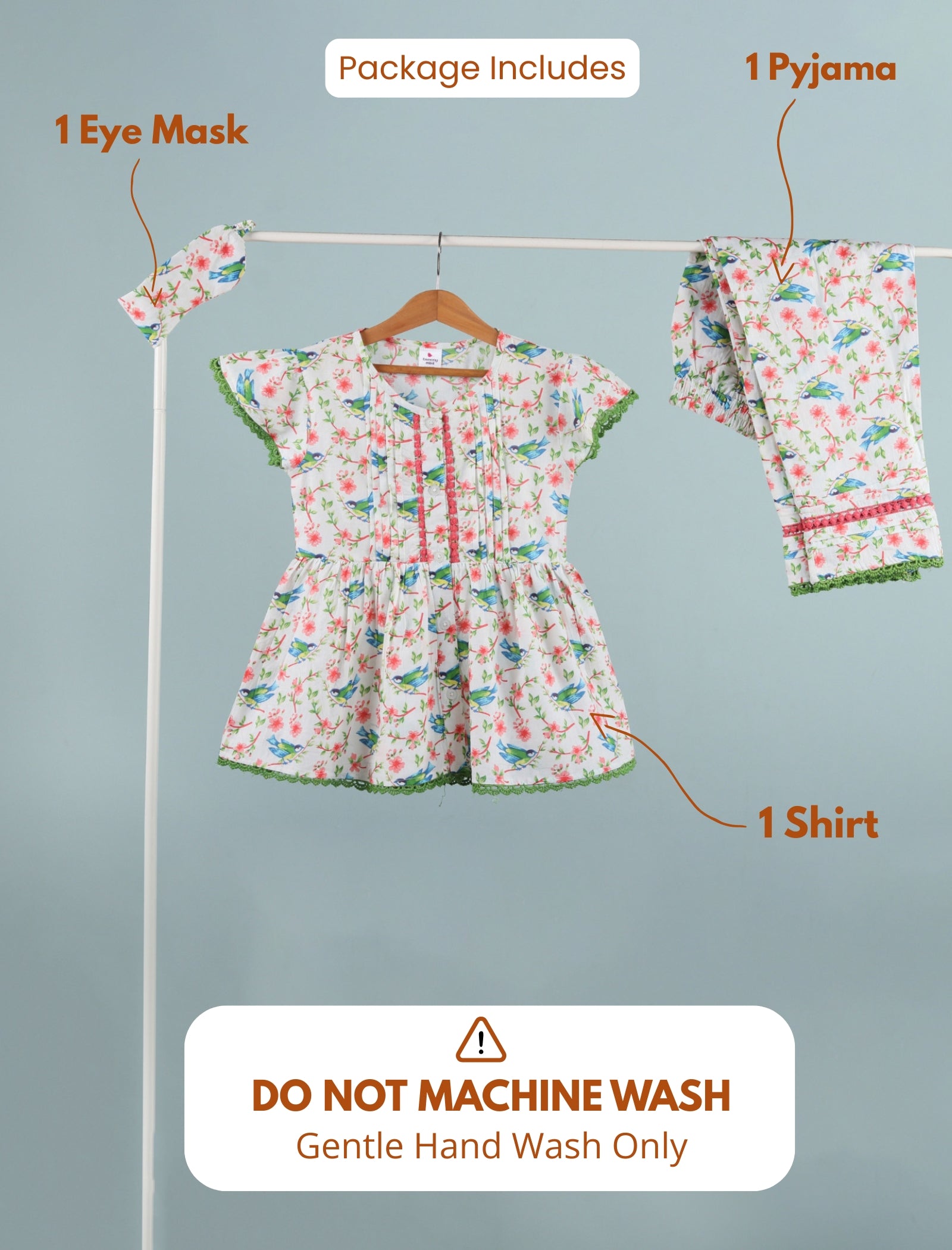 Set of children's clothing including a shirt, pajama, and eye mask on a rack with washing instructions.