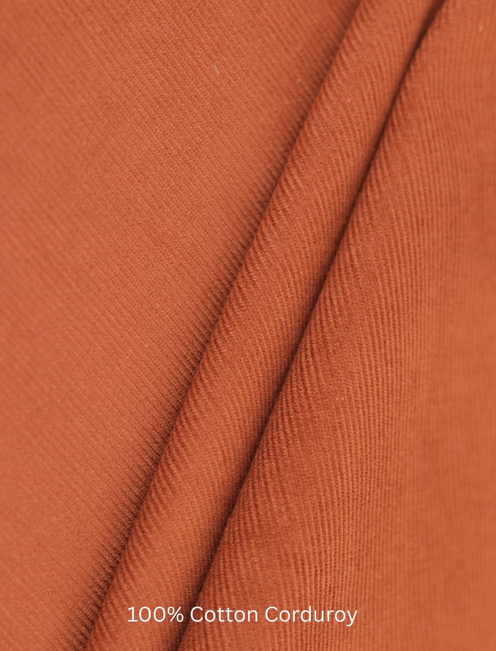 Close-up of rust corduroy fabric with '100% Cotton Corduroy' text.