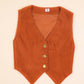Rust  vest with gold buttons on a beige background