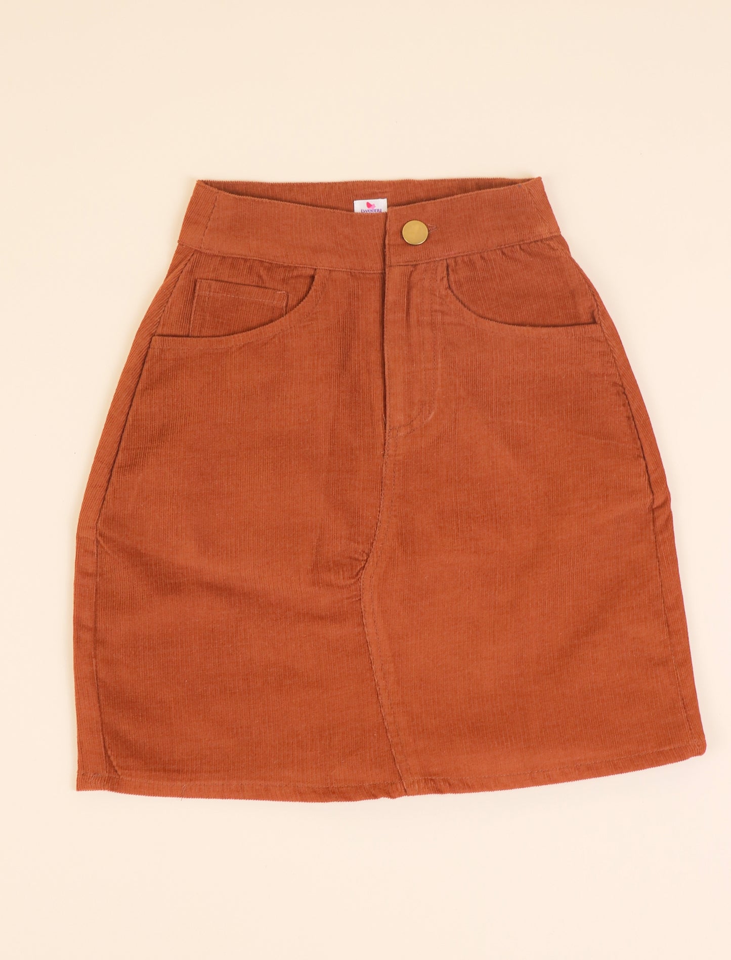 Girls skirt with a button on a beige background