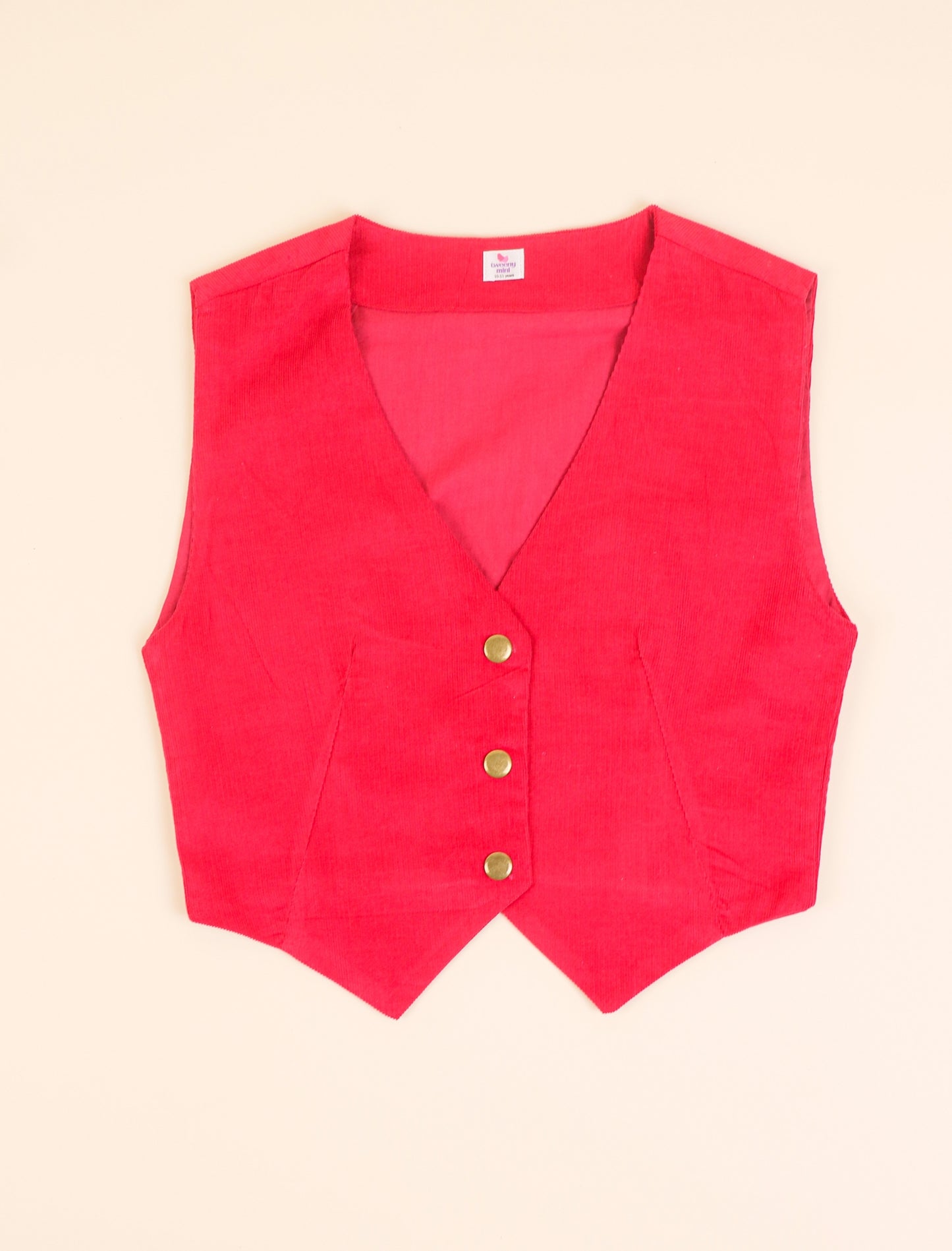 Red vest with gold buttons on a beige background