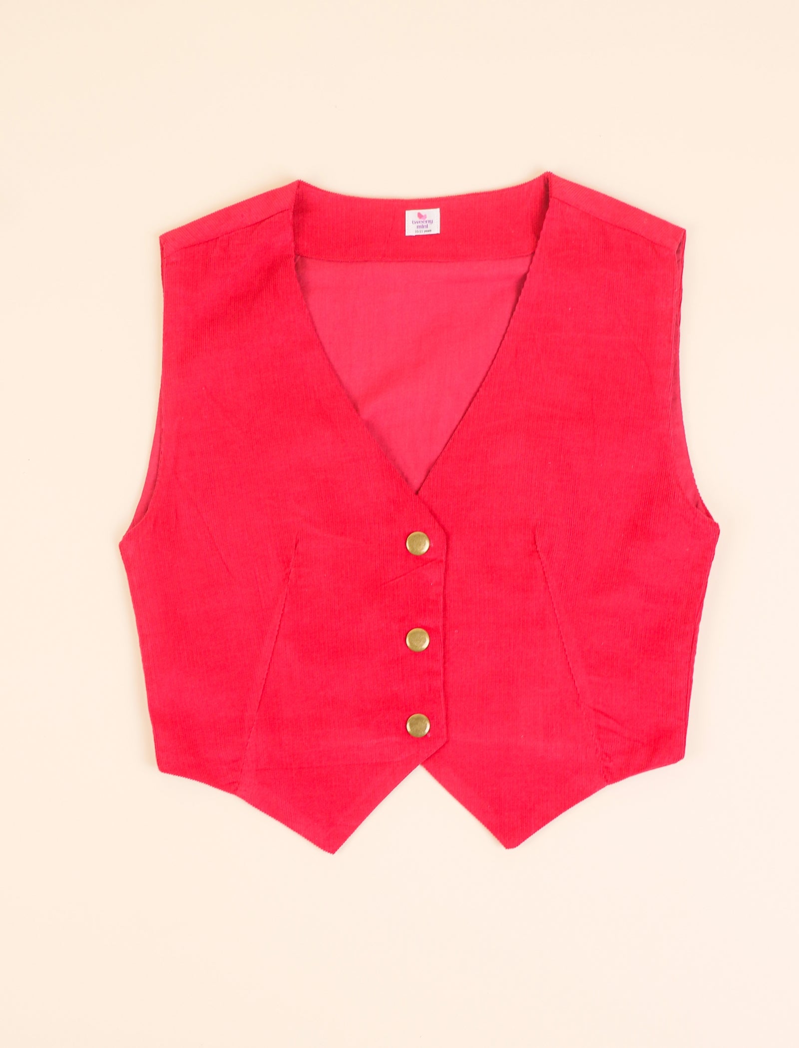 Red vest with gold buttons on a beige background