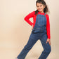 Girls wearing a red shirt and blue denim overalls on a beige background