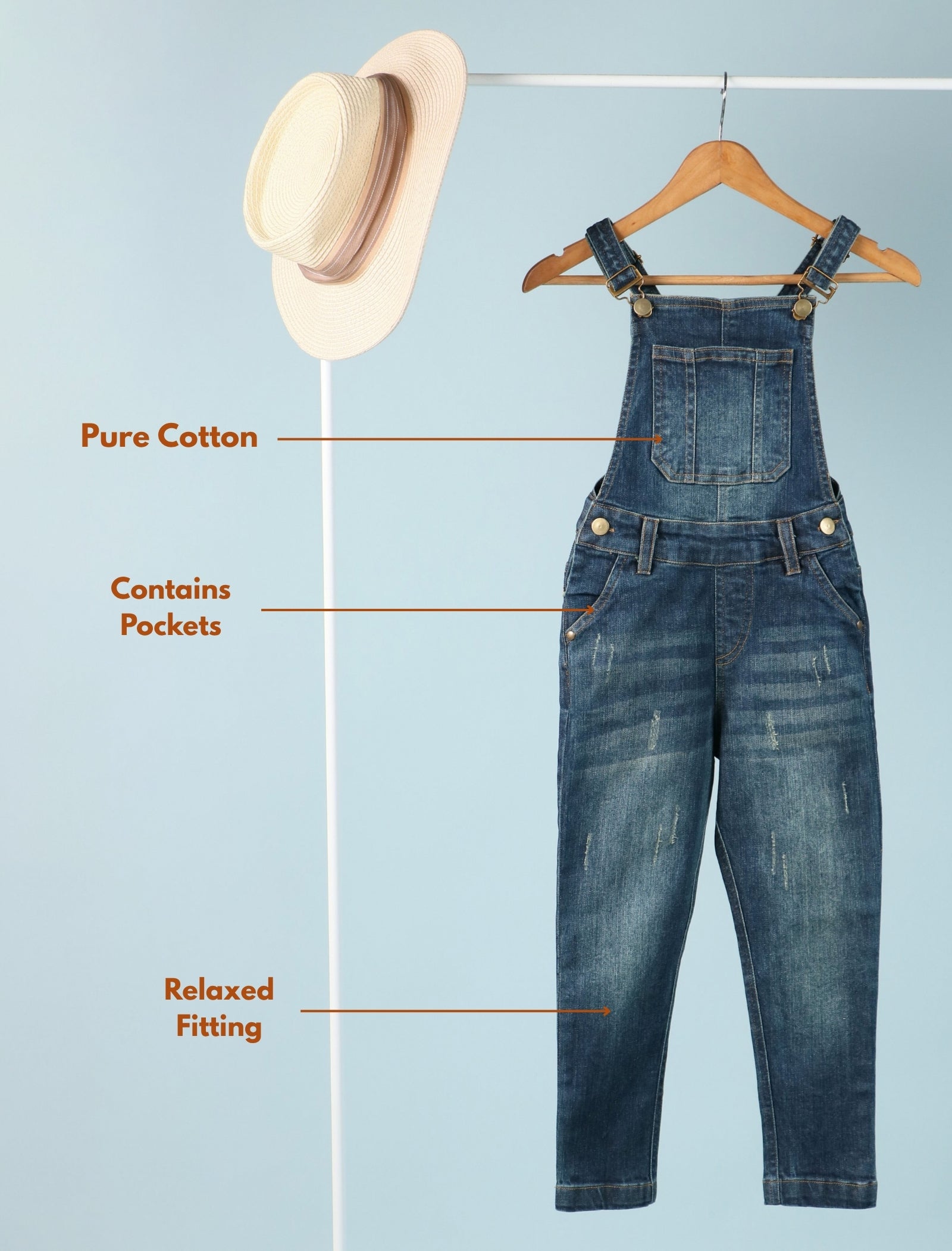 Blue denim overalls on a hanger with text highlighting features on a light blue background