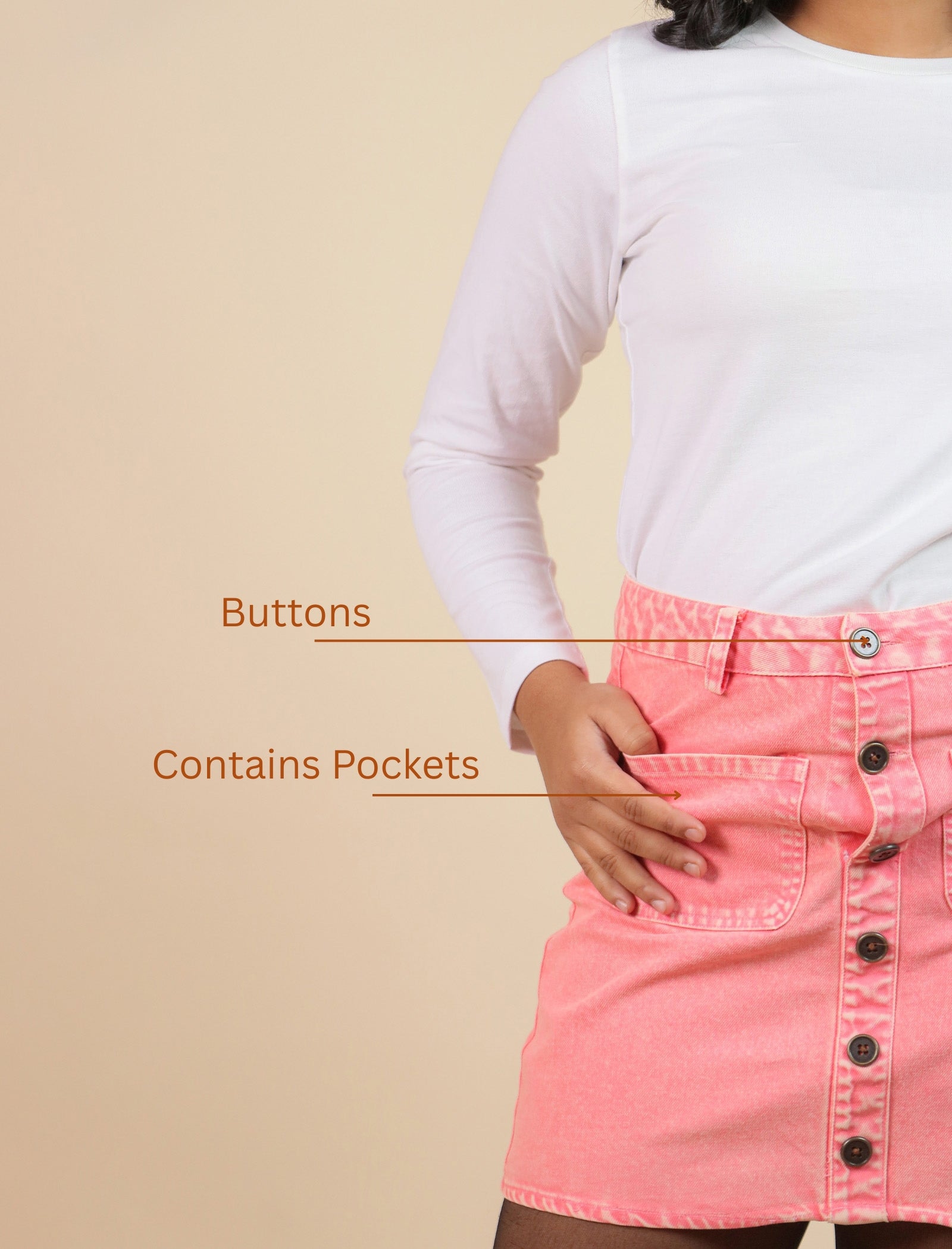 Girls wearing a pink skirt with button details on a beige background