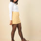 Girls wearing a beige skirt and brown boots on a beige background