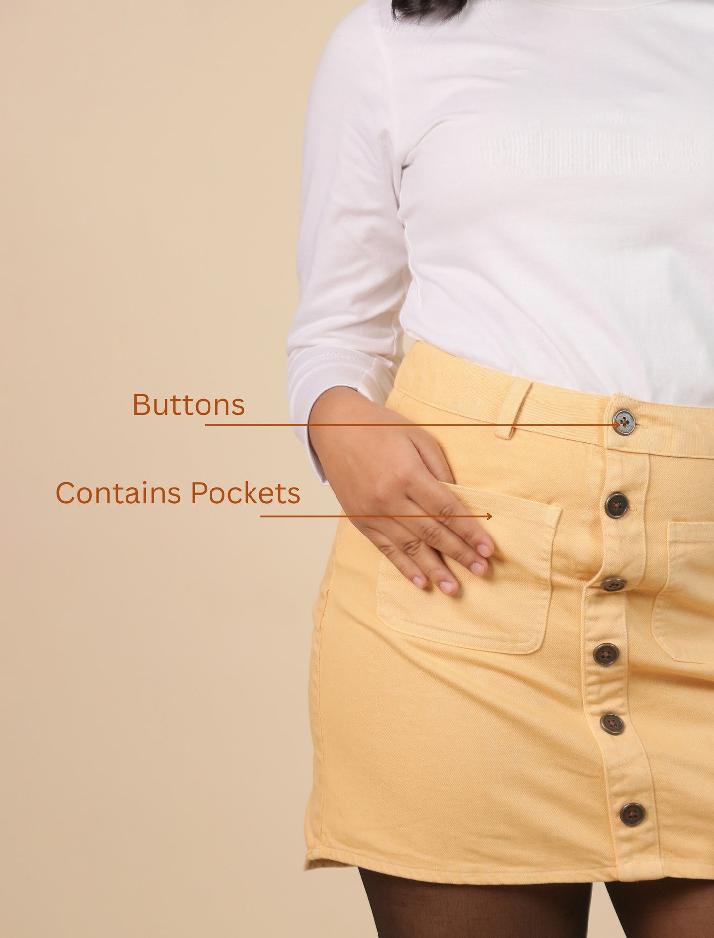 Butterscotch skirt with buttons and pockets on a beige background