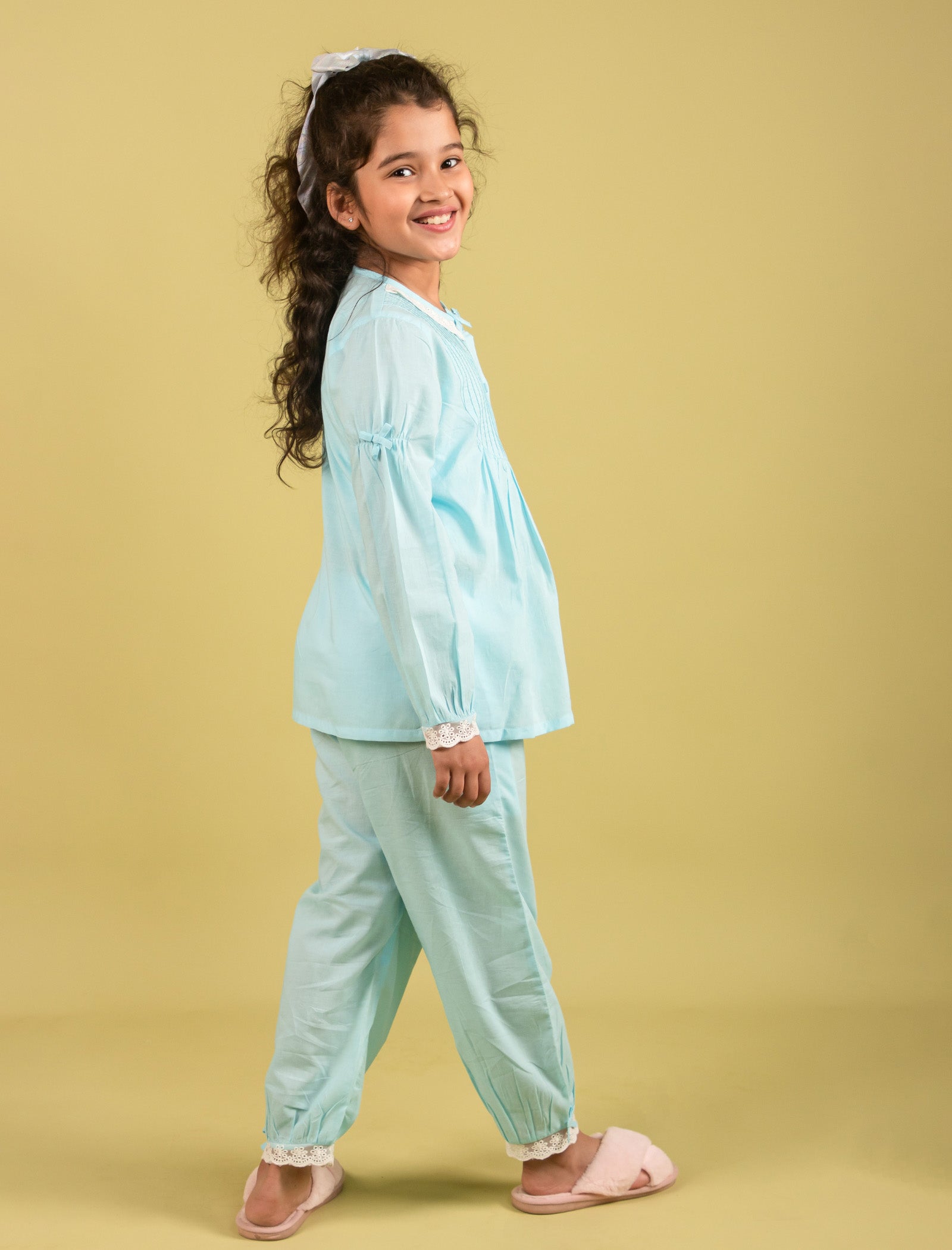 Girls wearing a light blue outfit on a beige background