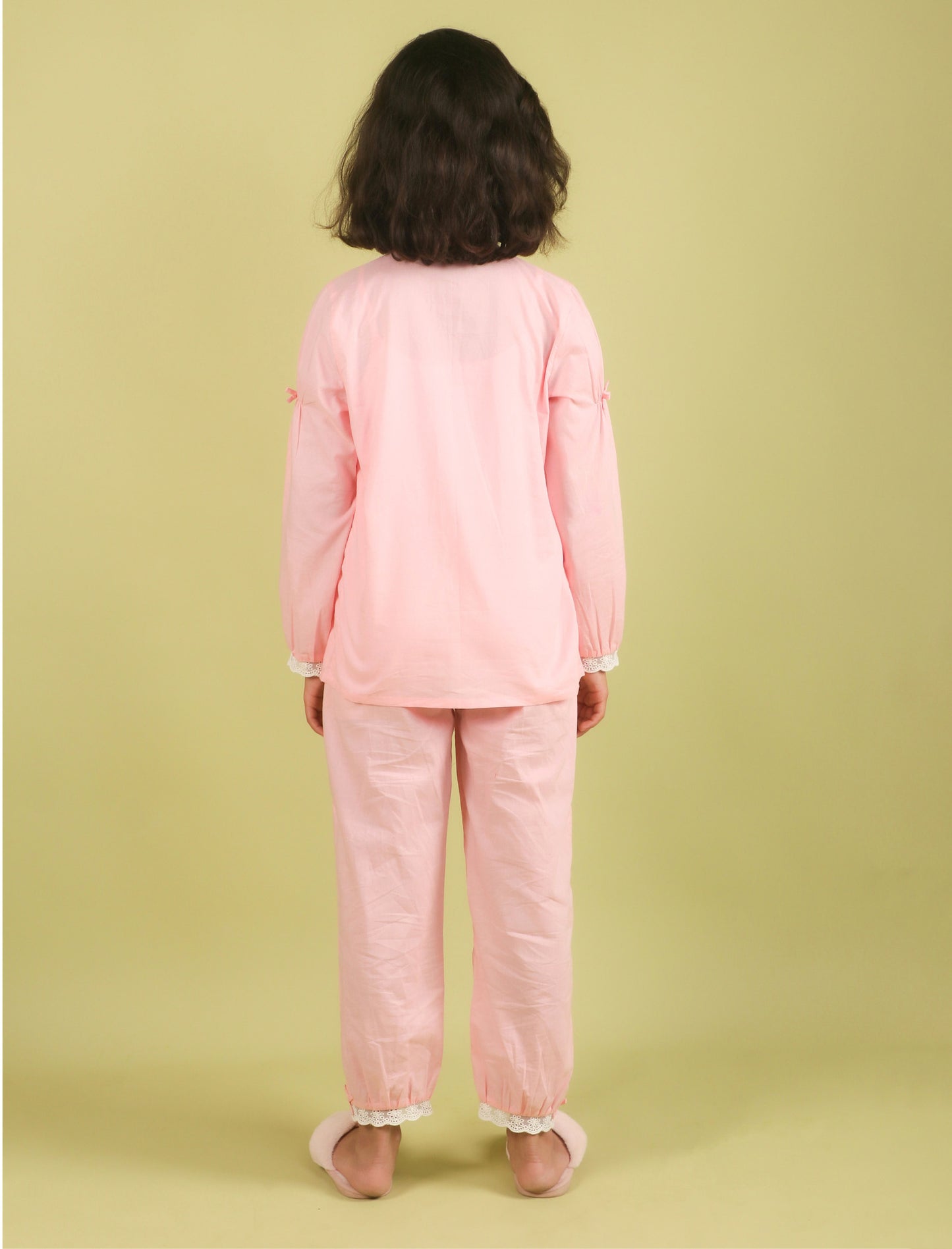 Child wearing a pink outfit on a green background
