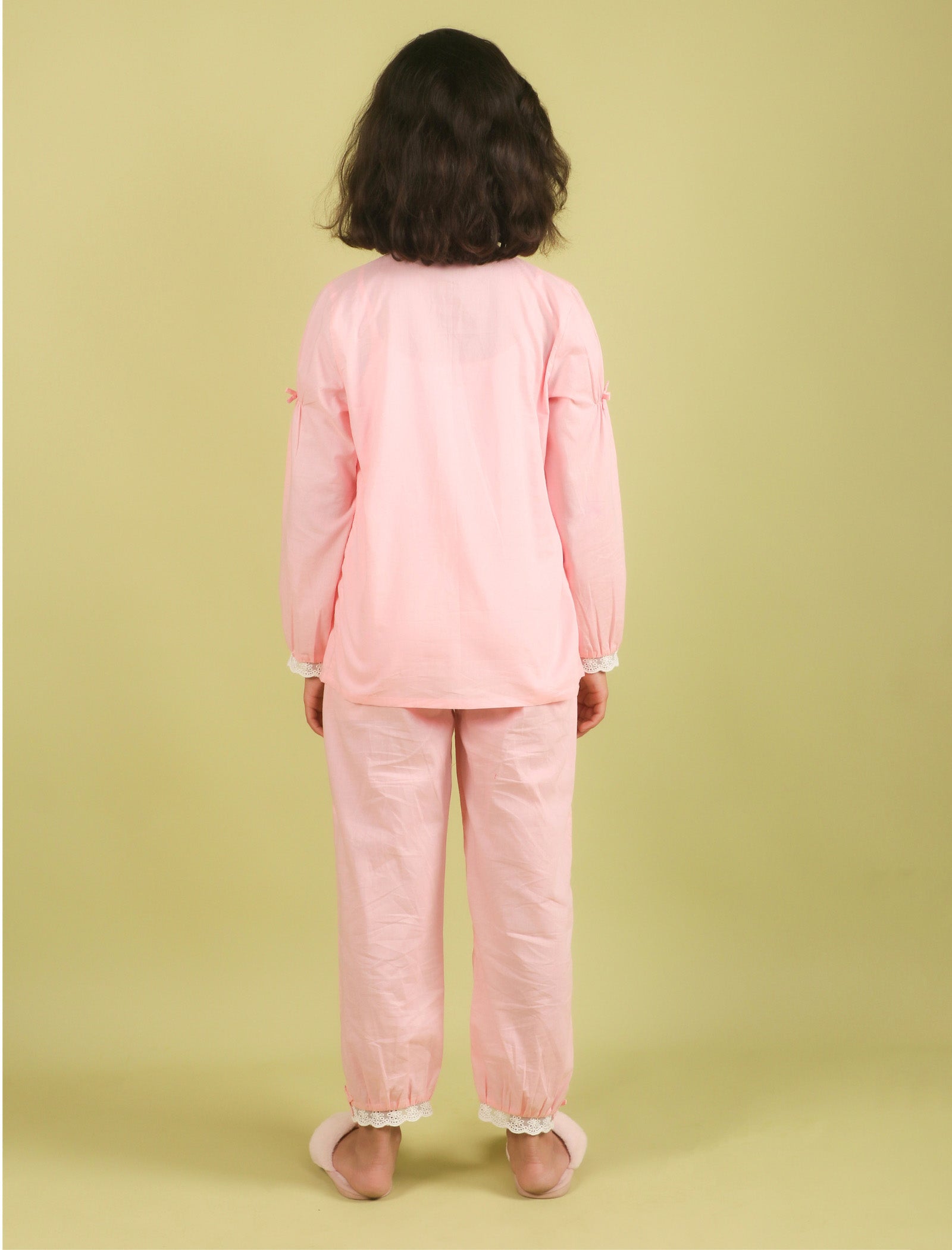 Child wearing a pink outfit on a green background