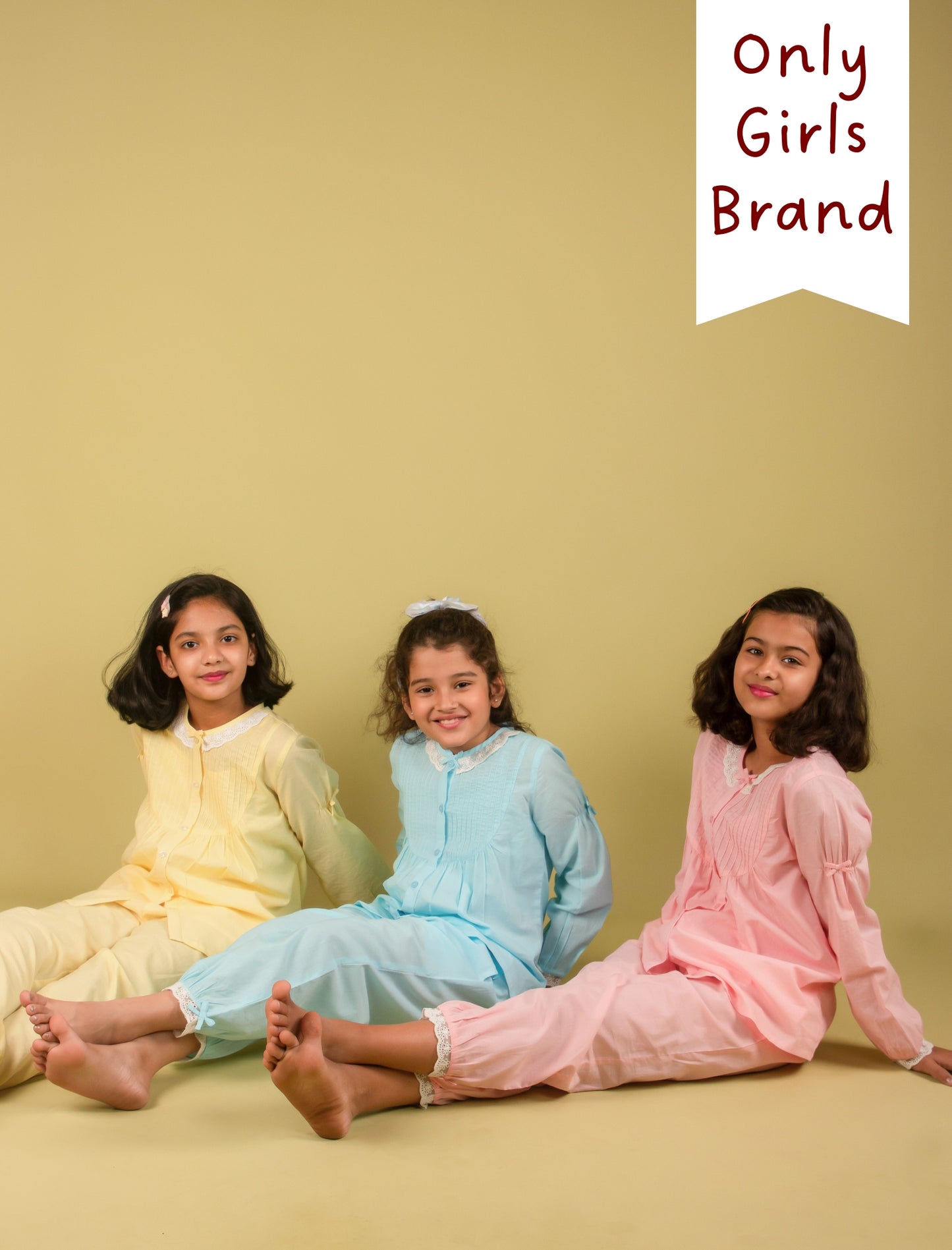Girls in pastel-colored outfits sitting on a yellow background with 'Only Girls Brand' text.