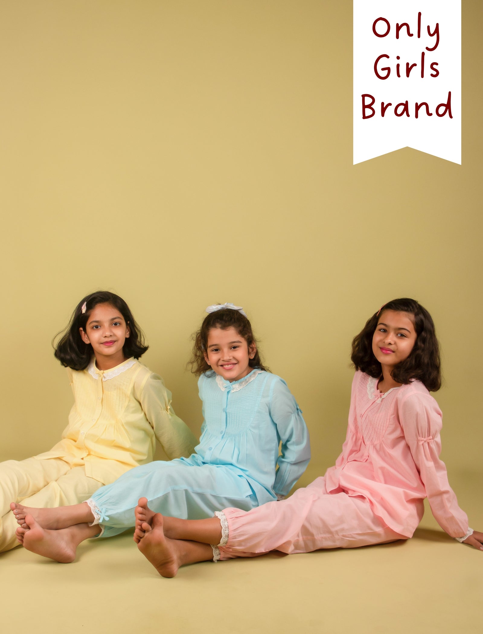 Girls in pastel-colored outfits sitting on a yellow background with 'Only Girls Brand' text.