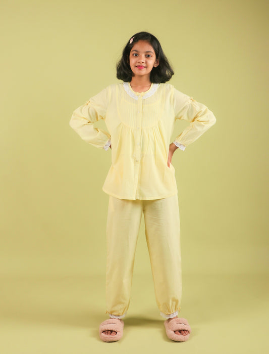 Girls wearing a yellow outfit with pink slippers on a light green background