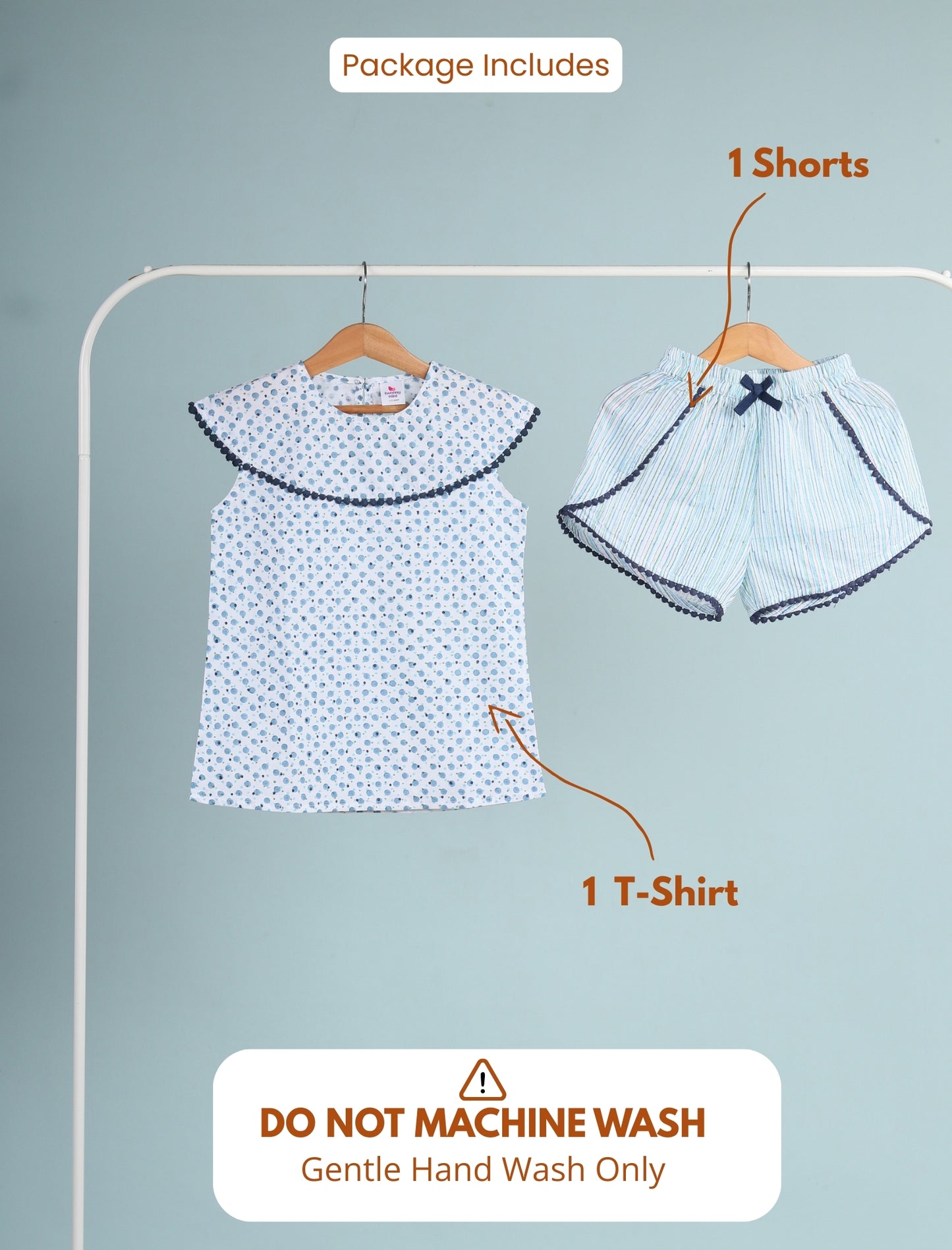 Girls clothing set with t-shirt and shorts on a hanger against a light blue background.