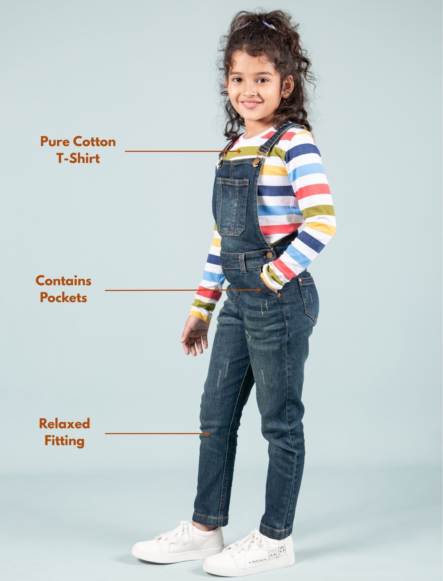 Girls wearing a colorful striped shirt and denim overalls with text highlighting features.