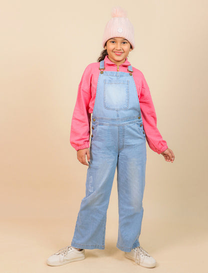 Girls wearing a pink sweatshirt, light blue denim overalls, and a pink beanie on a beige background