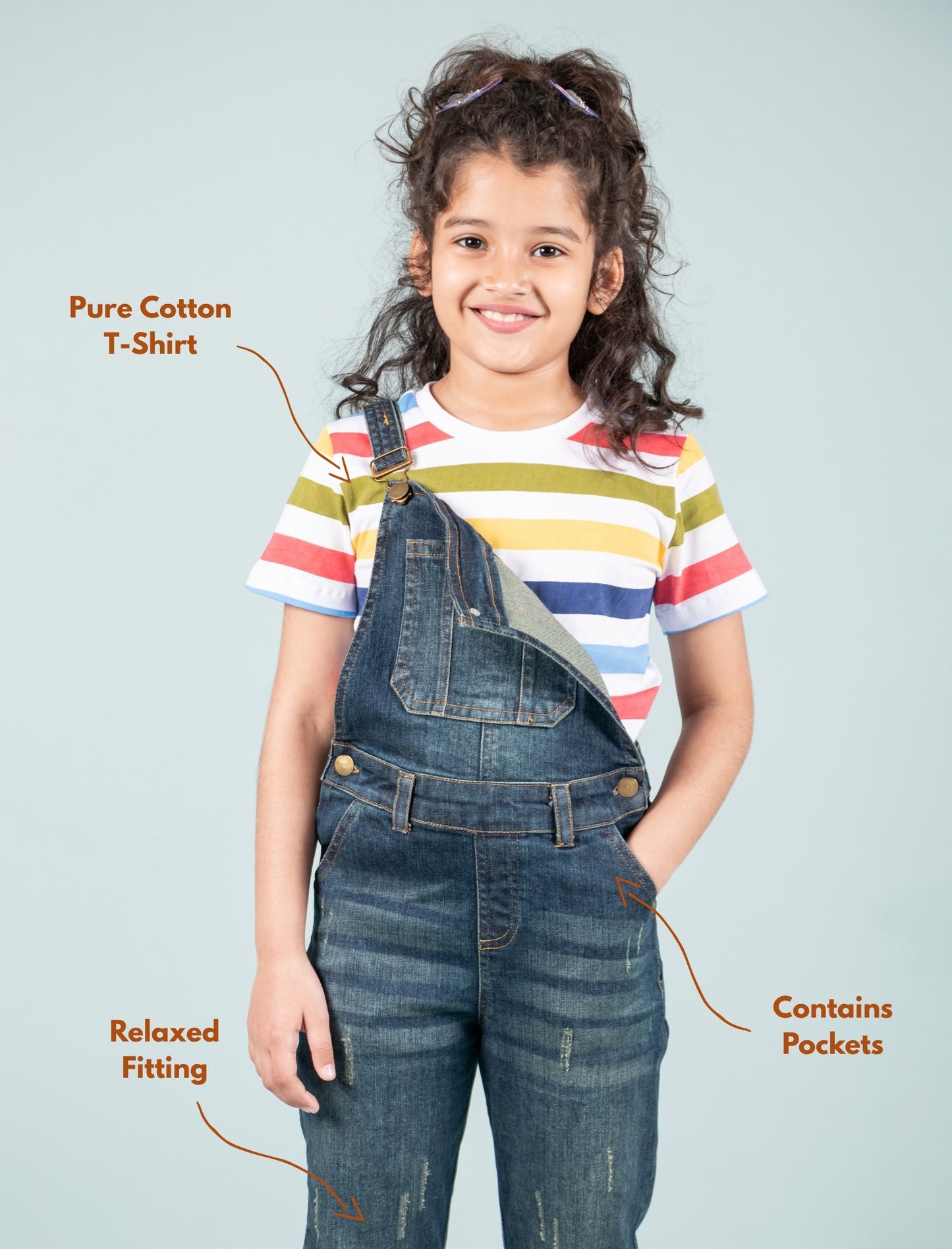 Girl wearing a striped t-shirt and denim overalls with text highlighting features.