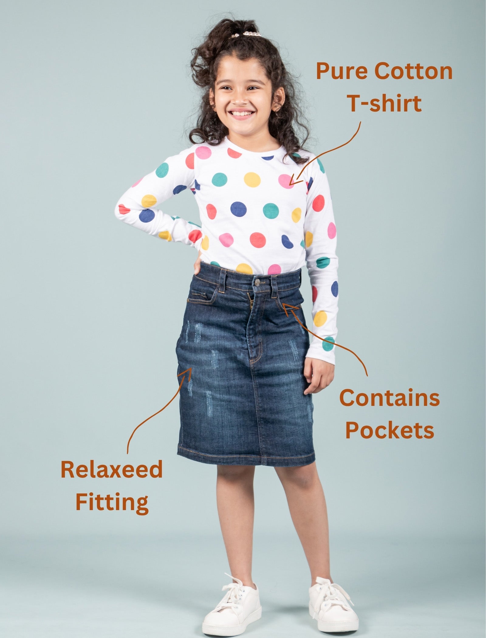Girl wearing a polka dot t-shirt and denim skirt with text highlighting features on a gray background