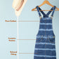 Striped denim dress on a hanger with a hat next to it on a light blue background