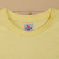Yellow t-shirt with a brand label on a beige background