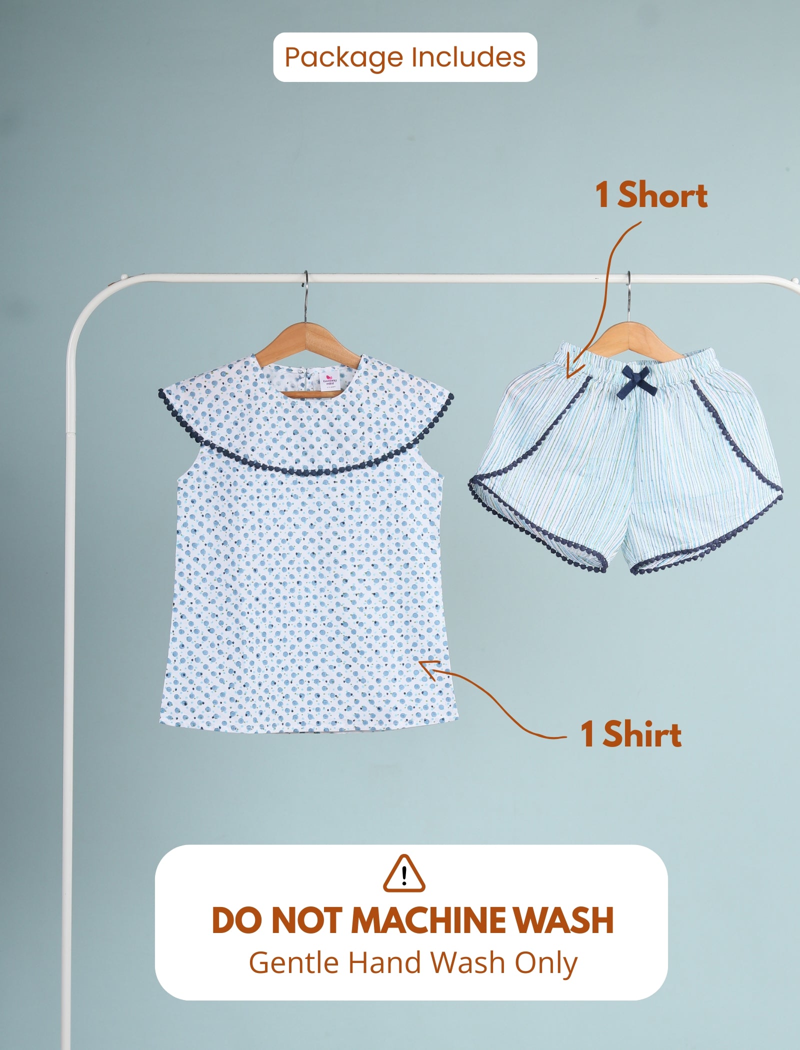 Girls shirt and shorts on hangers with washing instructions on a gray background
