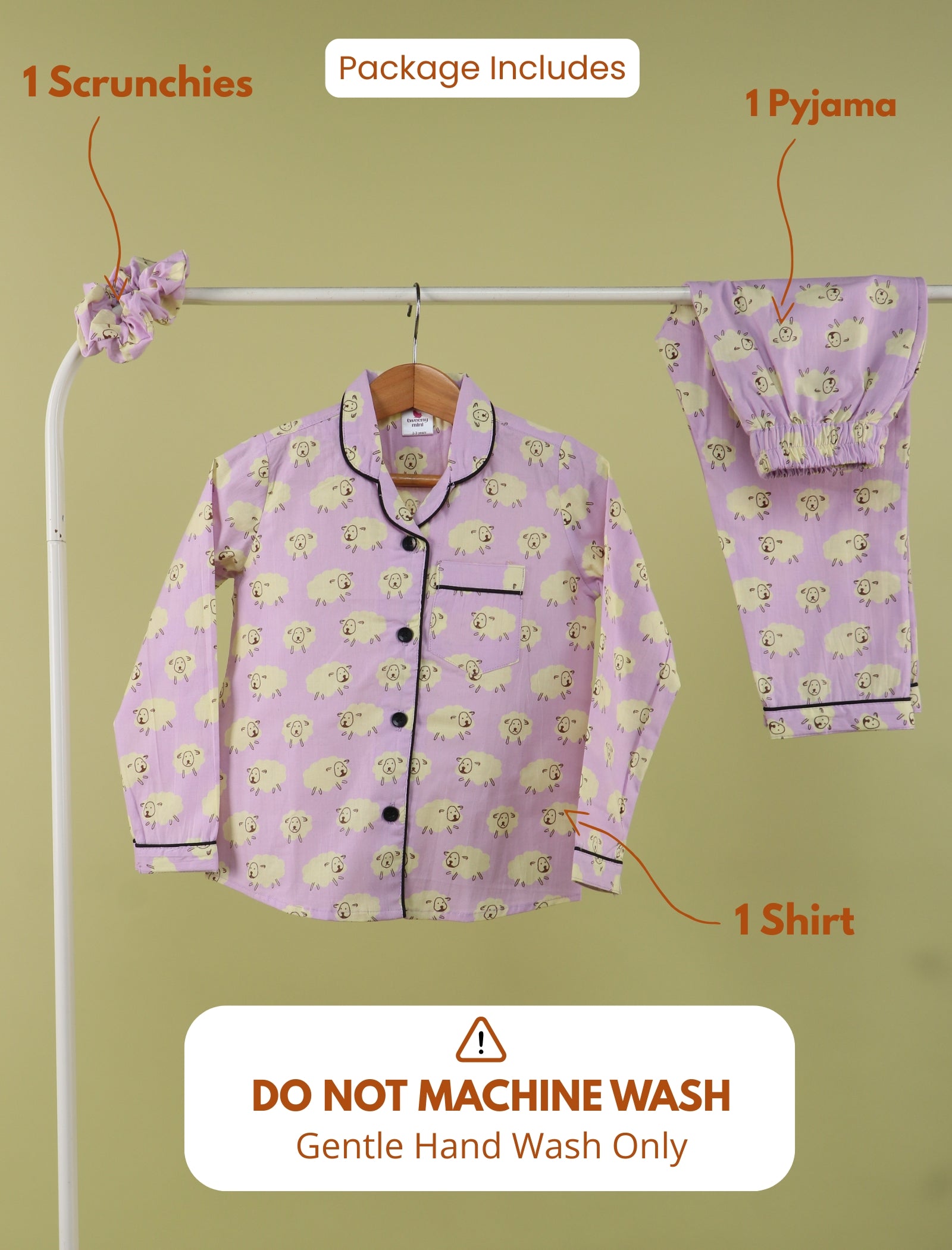 Purple pajama set with sheep pattern on a hanger against a green background