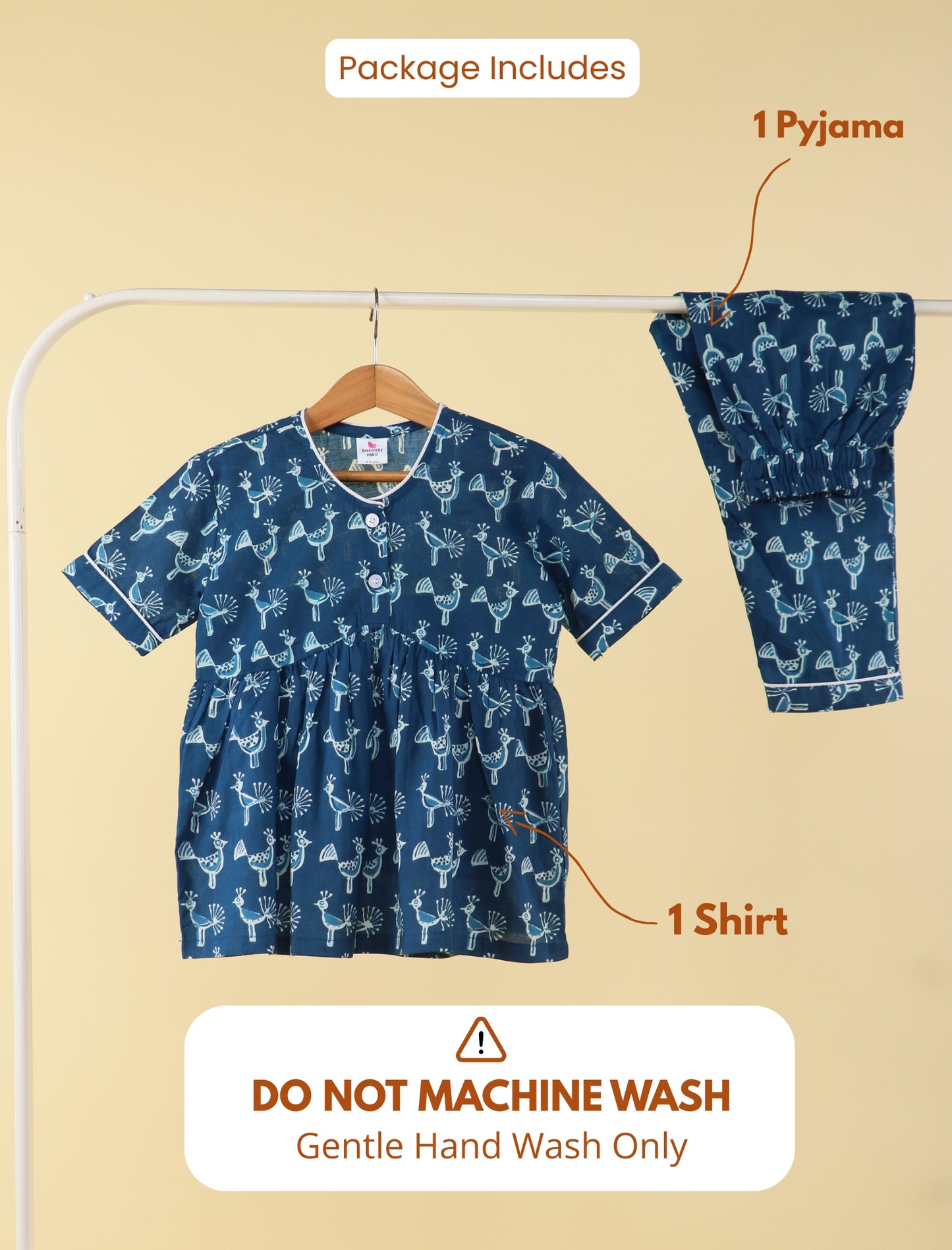 girl blue pajama set with shirt and pants on a hanger against a beige background.