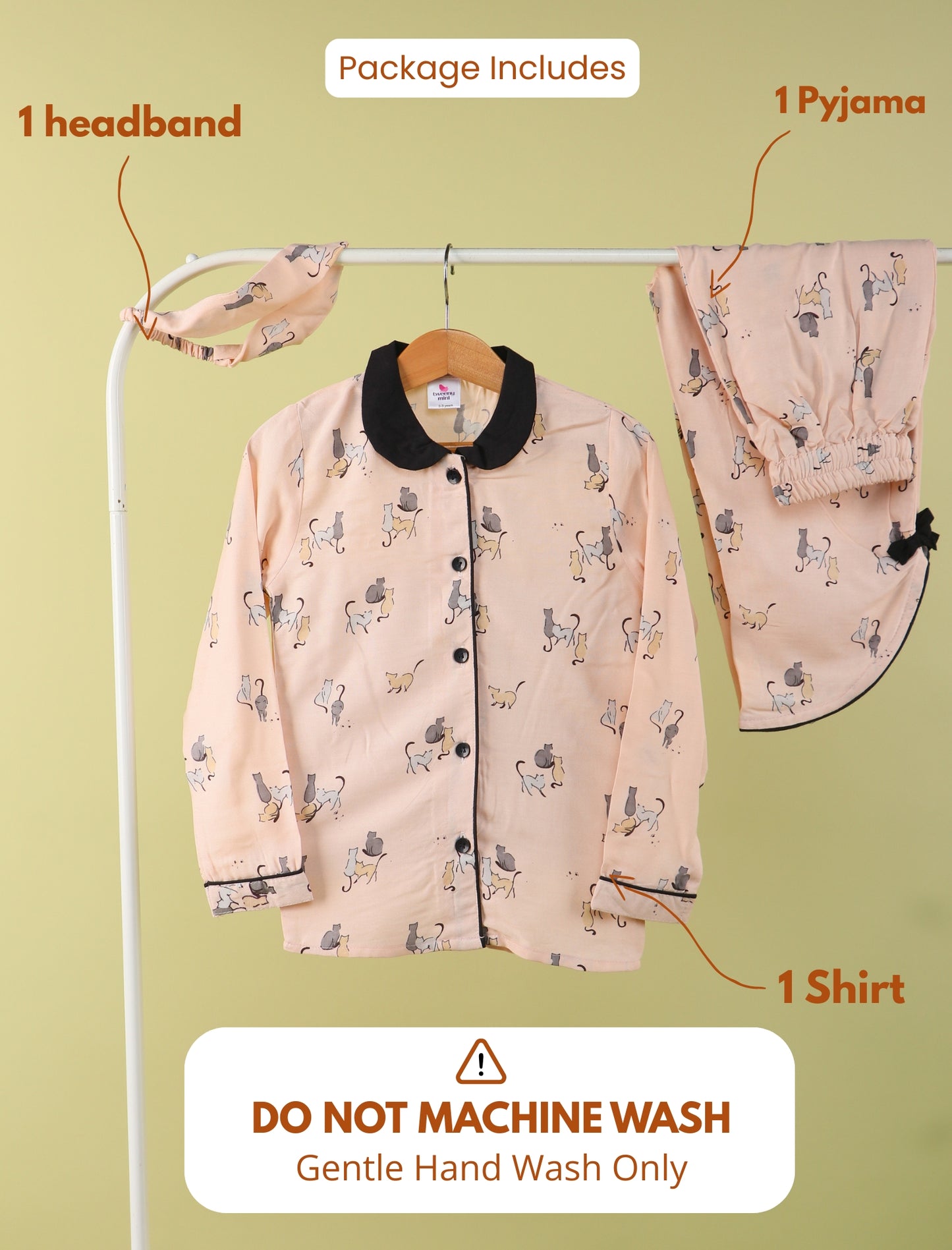 Girls pajama set with headband and shirt on a hanger against a green background.