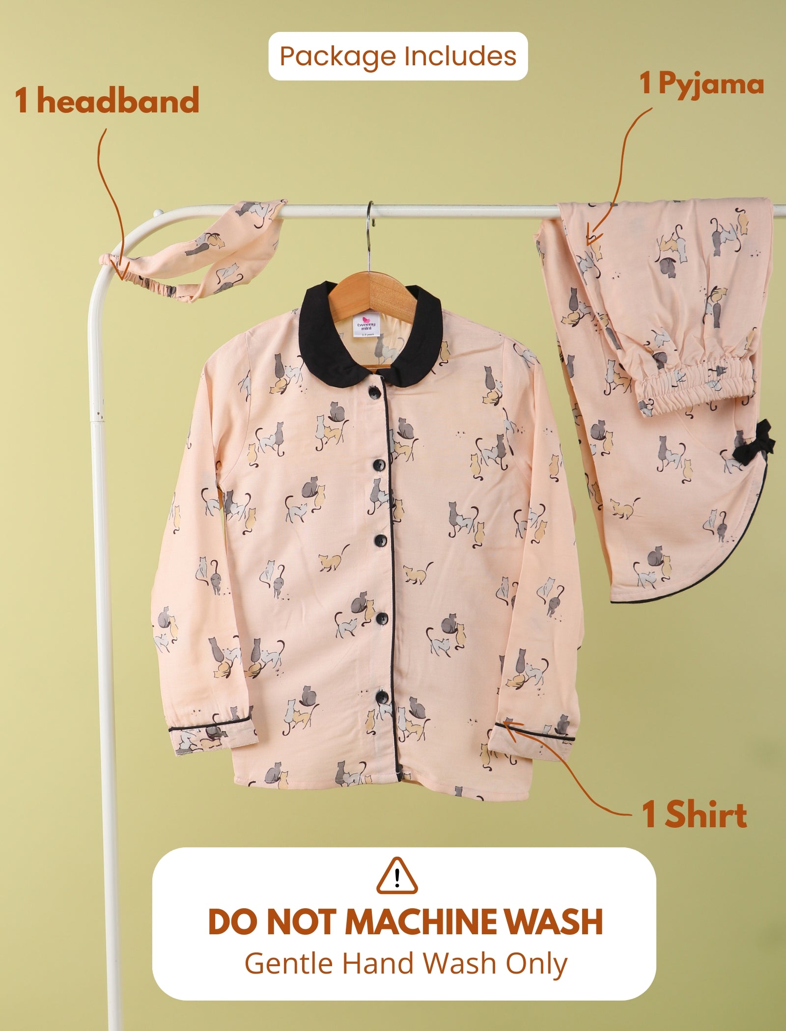 Girls pajama set with headband and shirt on a hanger against a green background.