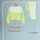 Green hoodie sweatshirt and jogger pants on a rack against a light blue background