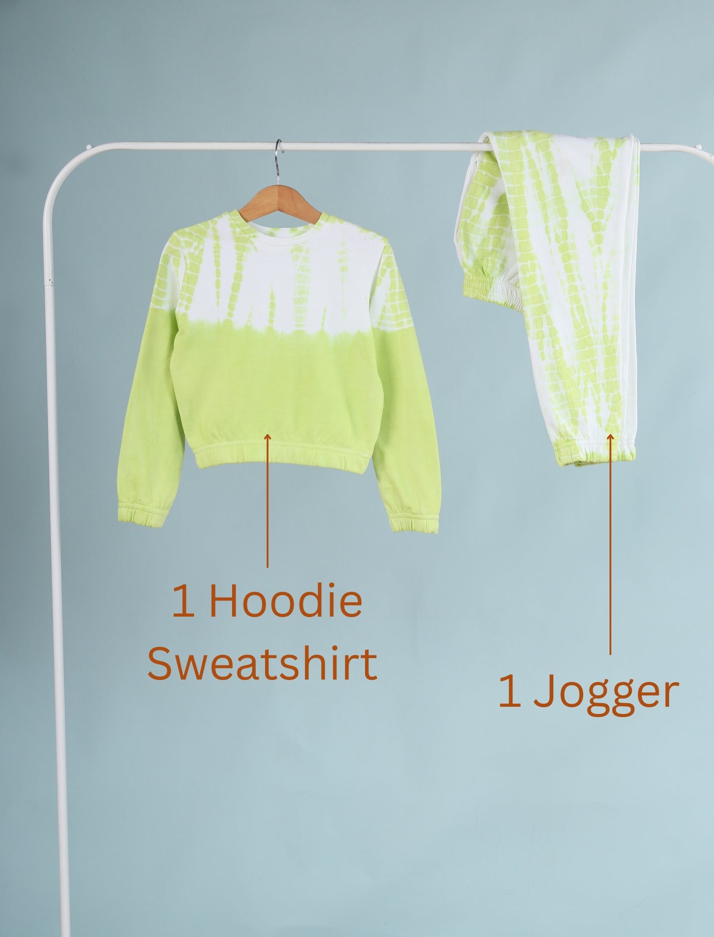 Green hoodie sweatshirt and jogger pants on a rack against a light blue background