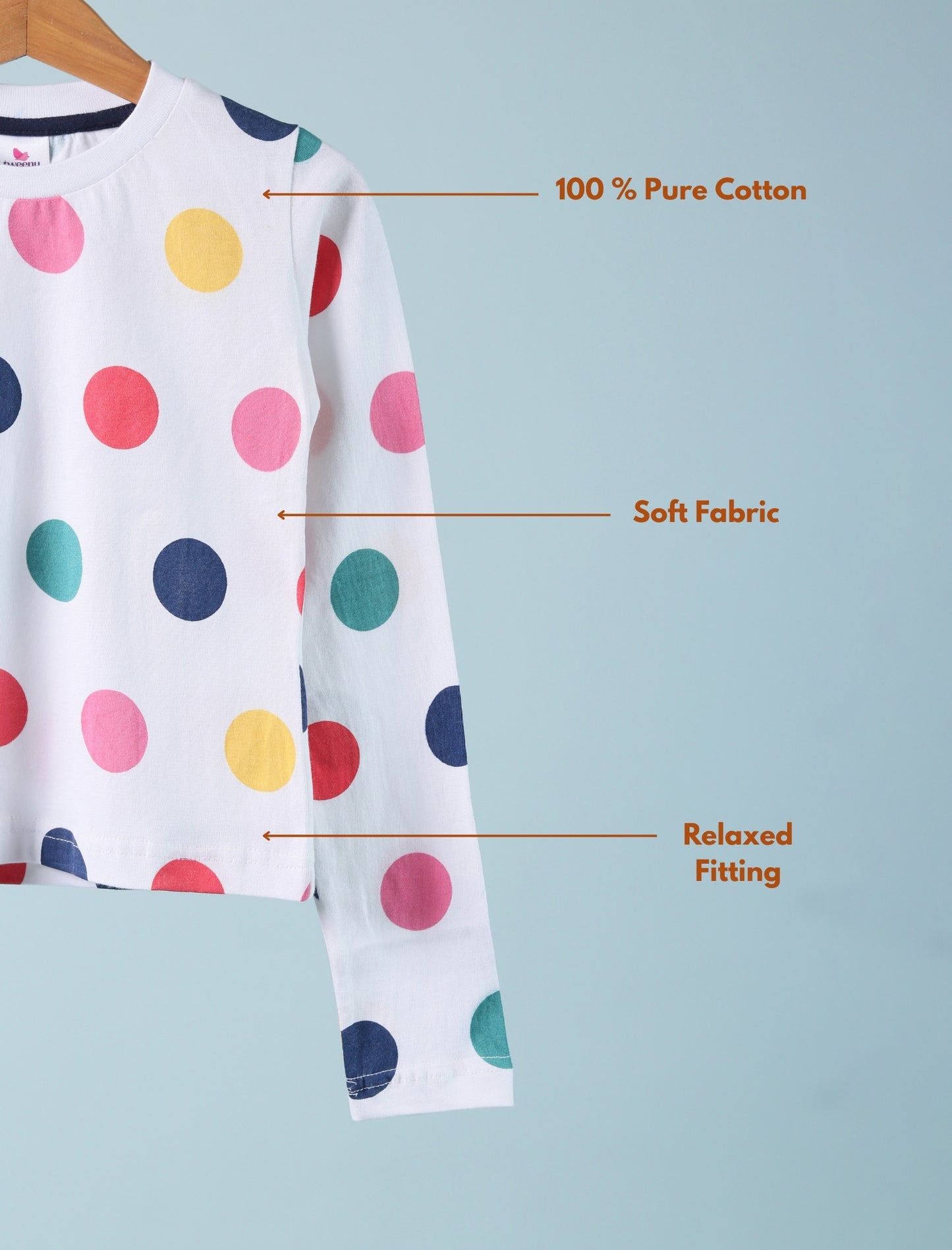 Polka dot shirt on a hanger with text indicating '100% Pure Cotton', 'Soft Fabric', and 'Relaxed Fitting' on a light blue background.