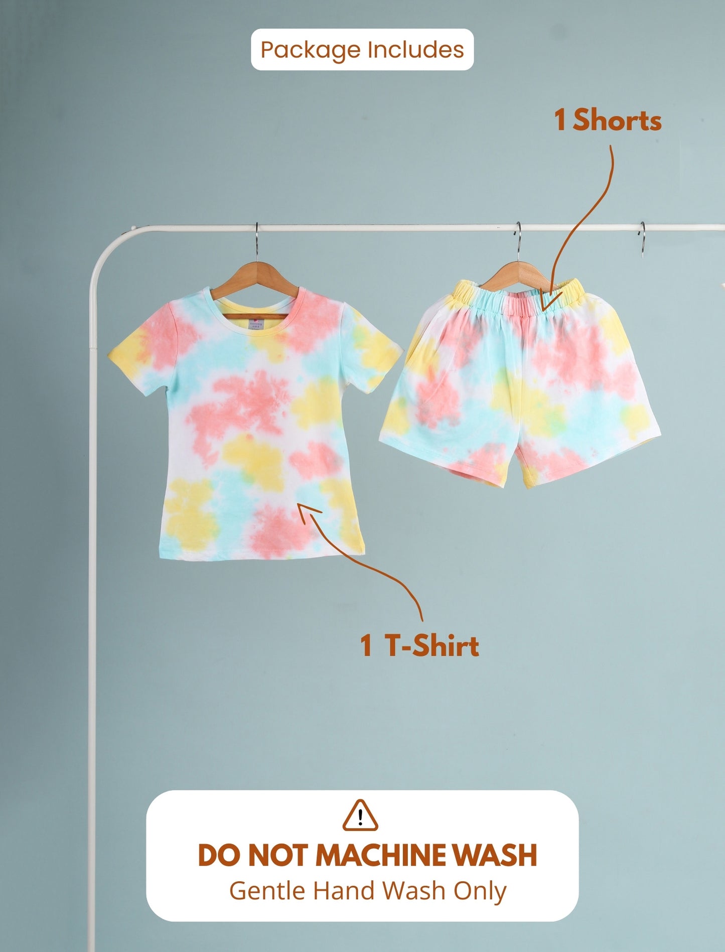 Set of tie-dye t-shirt and shorts on hangers with washing instructions.