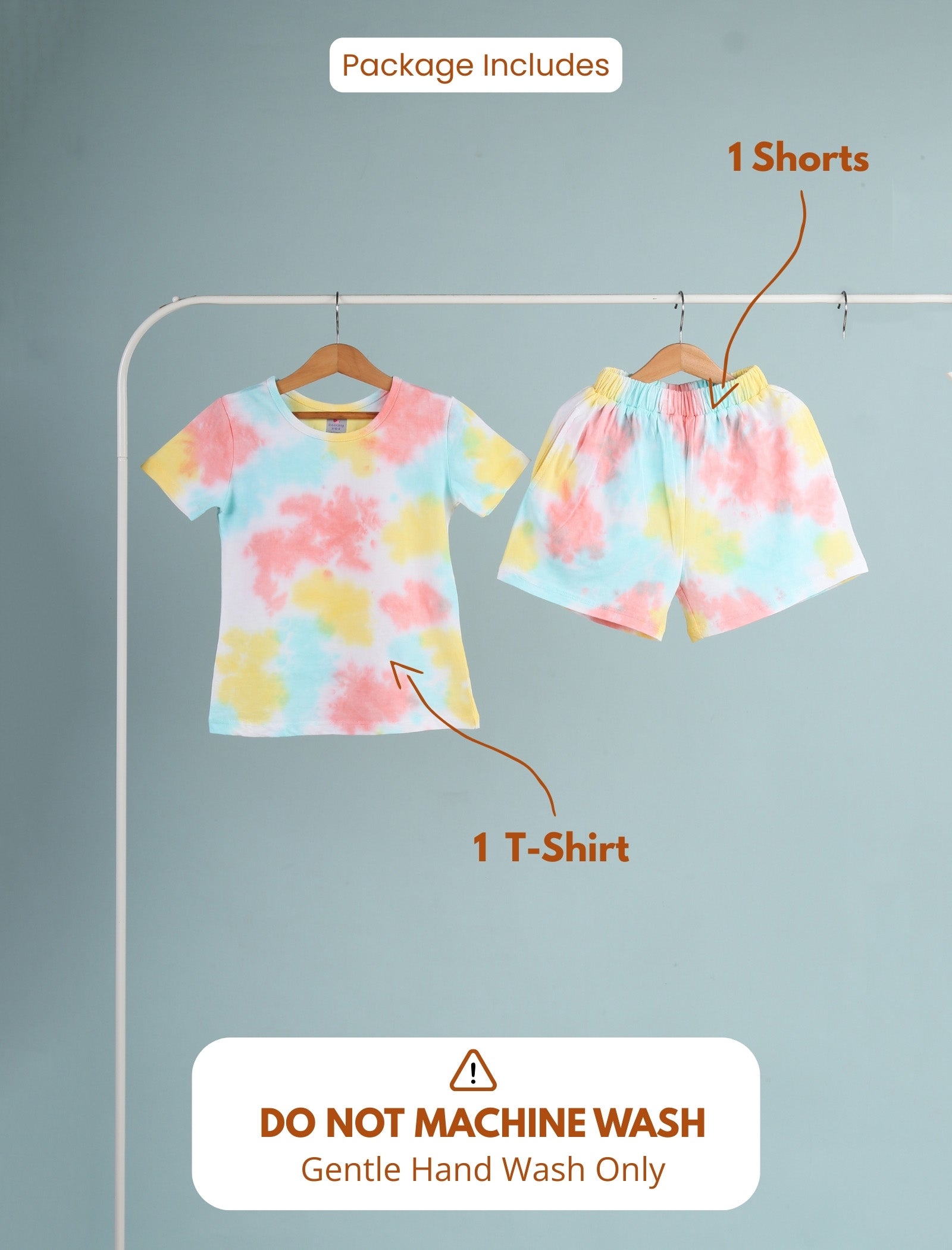 Set of tie-dye t-shirt and shorts on hangers with washing instructions.