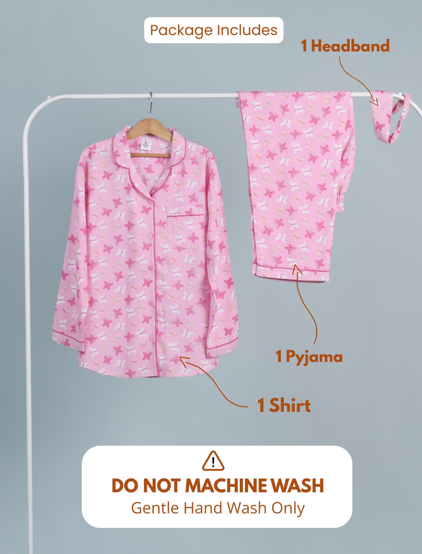 Pink pajama set with shirt, pants, and headband on a hanger against a gray background.