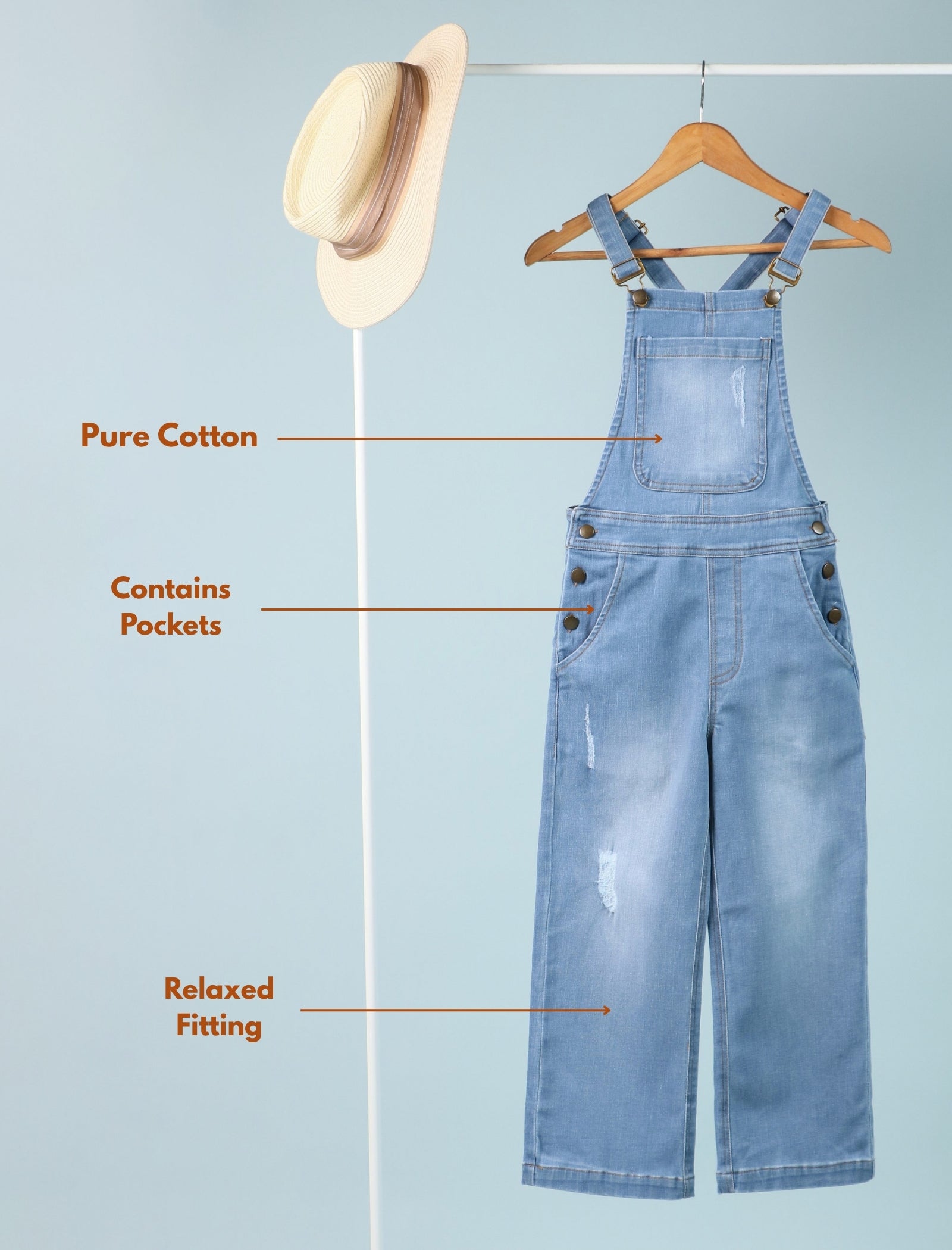 Blue denim overalls on a hanger with text highlighting features on a light blue background