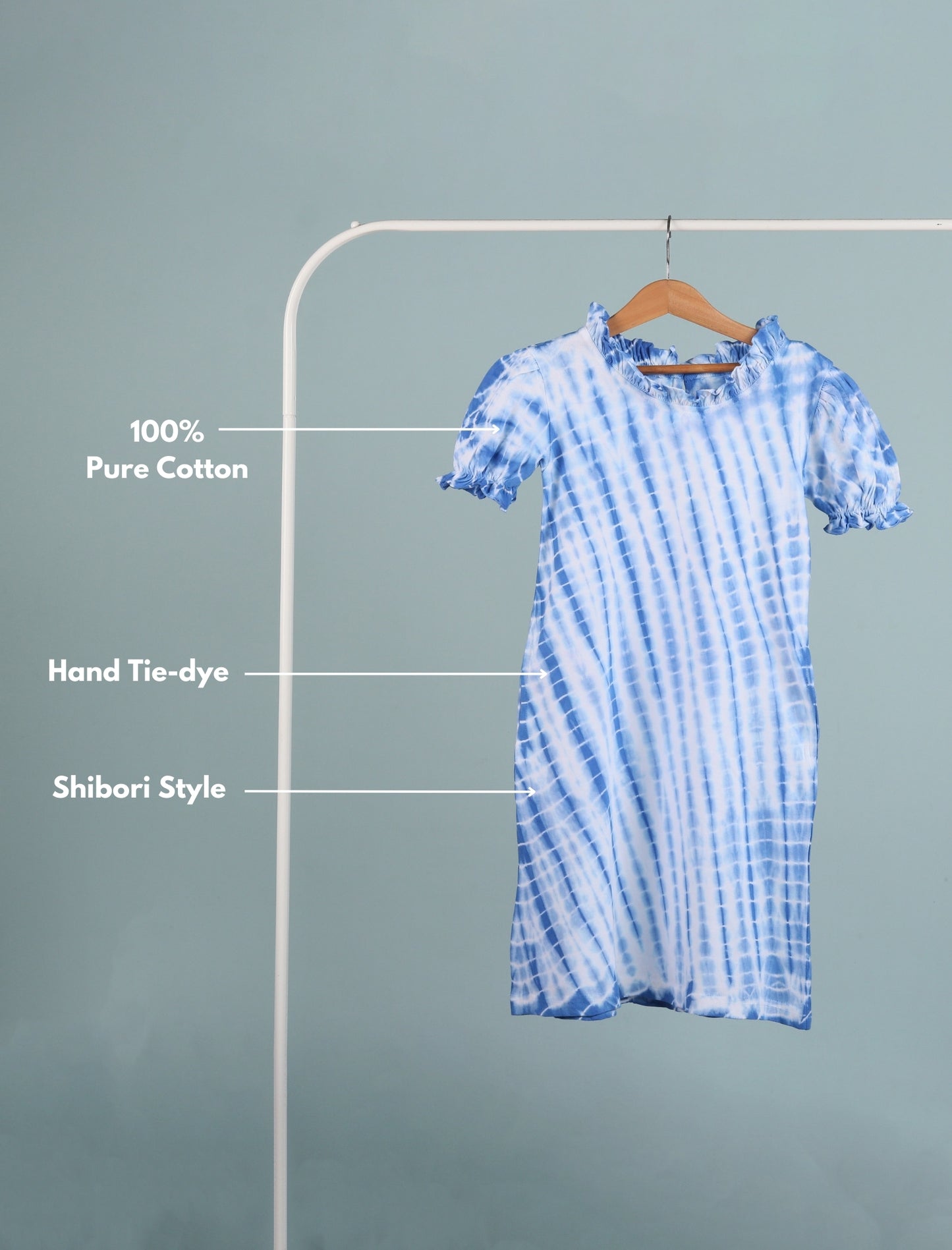 Blue and white tie-dye dress on a hanger with text labels on a gray background