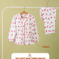 Girls kids pyjama set with shirt and pants on a hanger against a beige background.