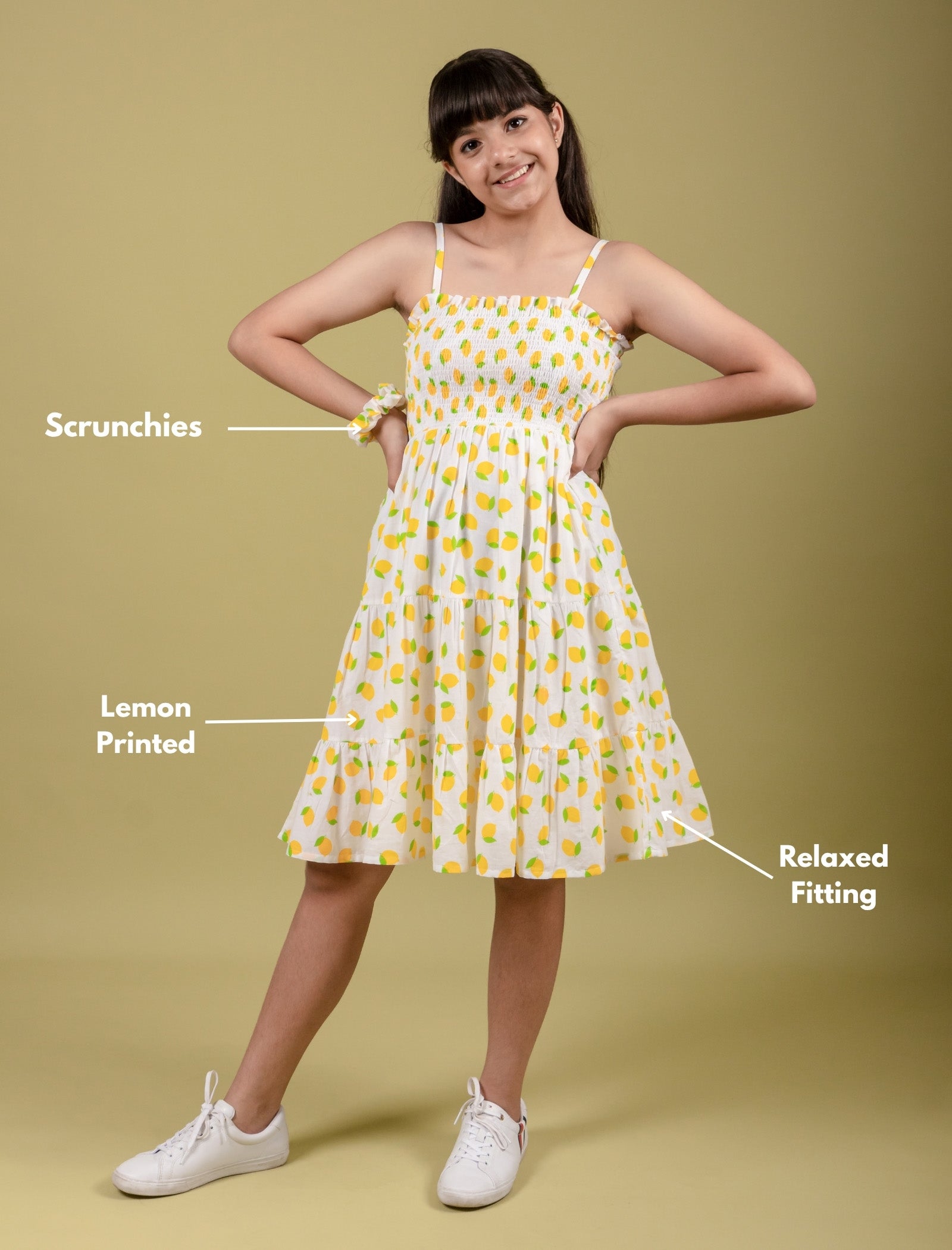 Girl wearing a yellow lemon printed dress on a beige background