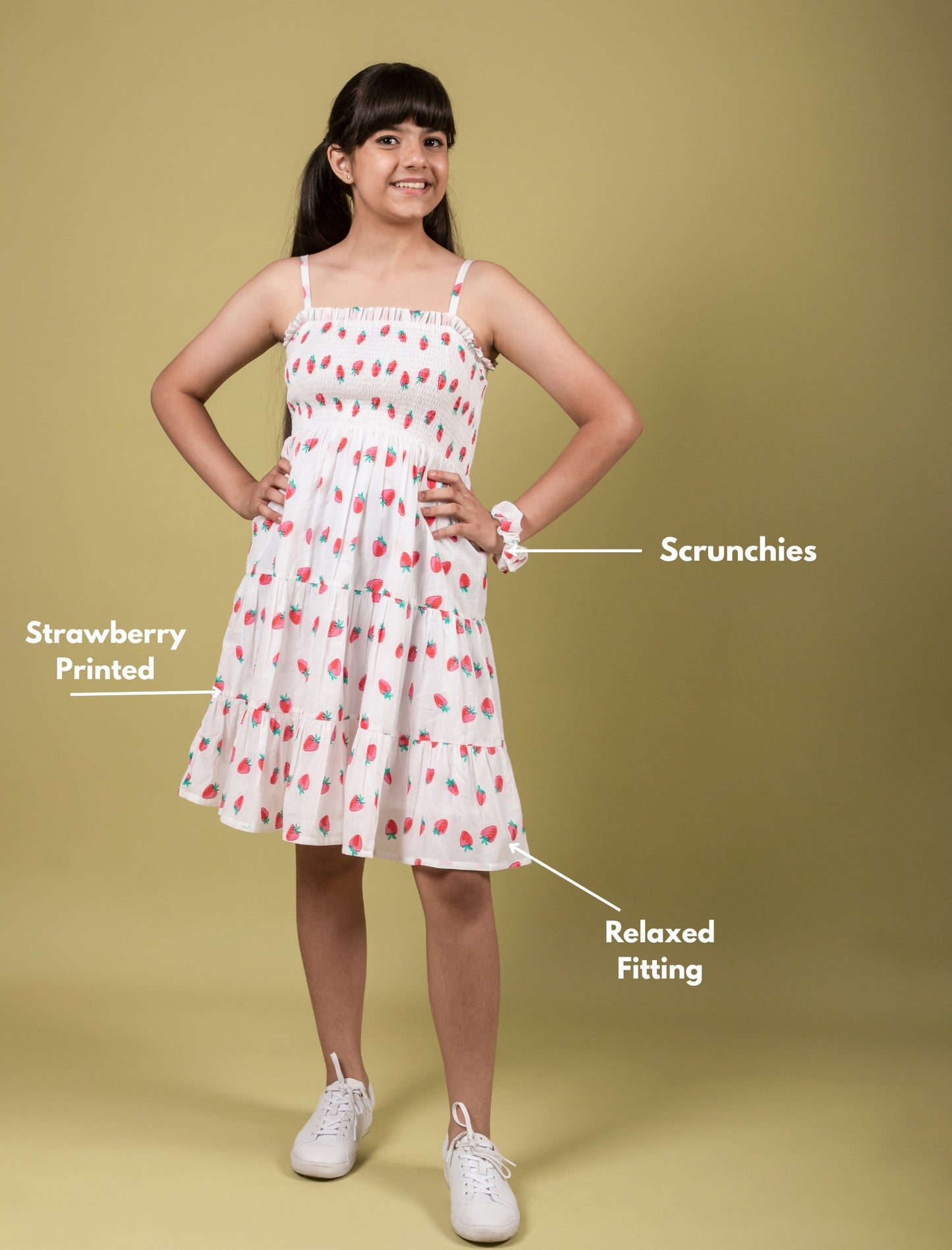 Girl wearing a strawberry printed dress with annotations on a beige background