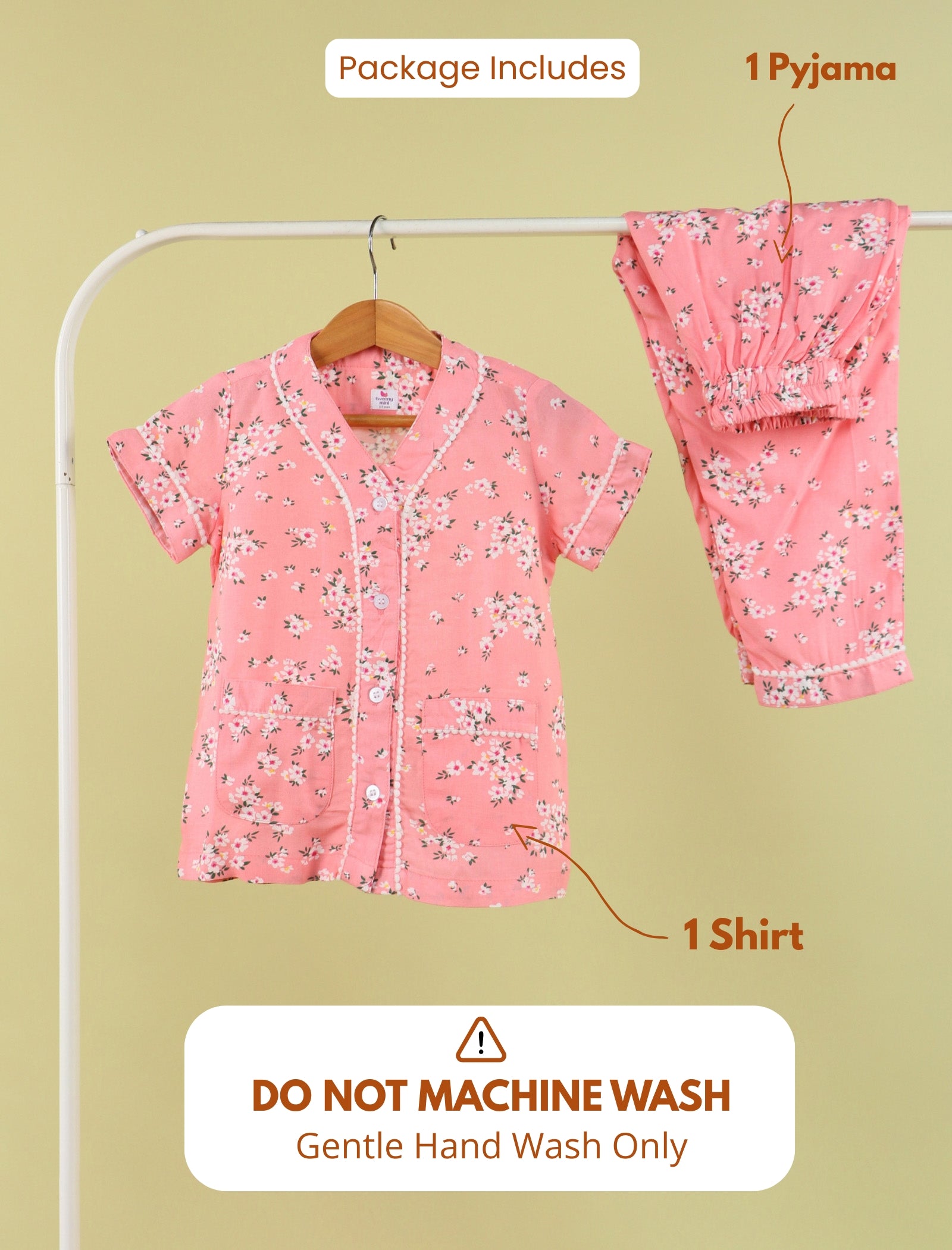 Pink floral pajama set with shirt and pants on a hanger against a beige background.