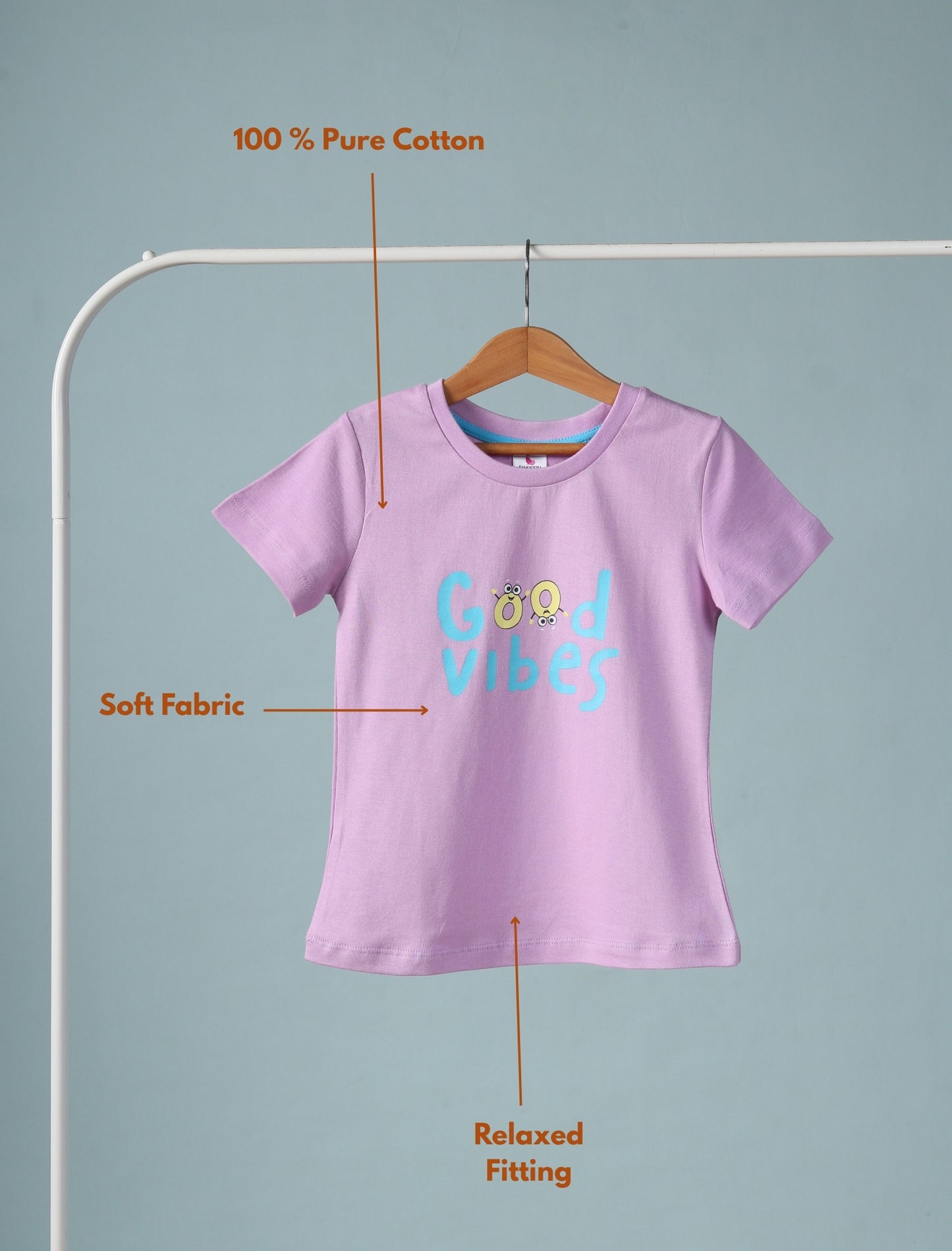 Purple t-shirt with 'Good Vibes' text on a hanger against a gray background